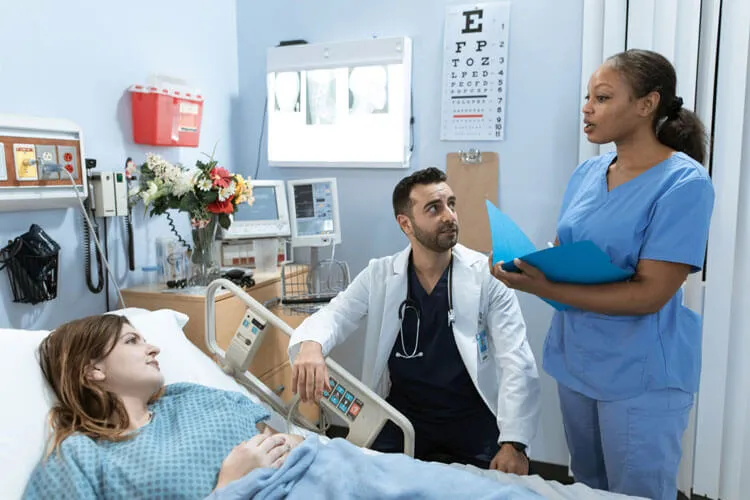 Doctor consulting with nurse while patient laying down